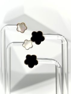 Add a touch of elegance and playfulness to your outfit with our Gold Clover Earrings. Made of 18k gold plated stainless steel, these earrings will dazzle and dance in the light, making your earlobes the star of the show! Perfect for both daytime adventures and nighttime escapades. How about you indulge in the luxurious choice of either black or white pearl? Or why not both?😍 Features: 18k Gold Plated High-Quality Stainless Steel Tarnish Free Modern Flower Shaped Earrings For Gift, Clover Earrings Gold, Black Enamel Clip-on Earrings For Evening, Formal Gold Clip-on Earrings With Black Enamel, Nickel-free Black Brass Earrings, Elegant Black Flower-shaped Earrings, Clover Earrings, White Pearl, The Star