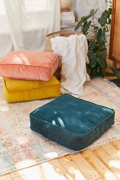 three different colored cushions sitting on the floor