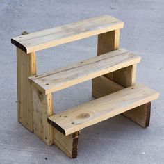 two wooden benches sitting next to each other on top of a cement ground with no one around them