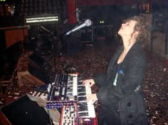 a woman is playing an electronic keyboard in a room full of confetti on the floor