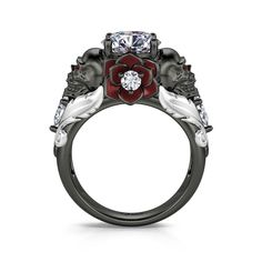 a black and white ring with red flowers on the side, surrounded by three diamonds