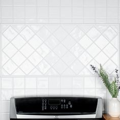 a black stove top oven sitting on top of a wooden counter next to a potted plant