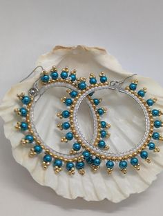 Add a touch of boho chic to your look with these stunning 2-inch Turquoise Glass & Gold Hoop Dangle Earrings. Featuring a vibrant turquoise glass bead suspended from a sleek stainless hoop, these earrings are both stylish and lightweight. Crafted with hypoallergenic materials, you can wear them with confidence all day long. Perfect for elevating any outfit, from casual to dressy, these earrings are a must-have accessory. Turquoise Metal Jewelry With Dangling Beads, Turquoise Beaded Teardrop Hoop Earrings, Turquoise Beaded Round Earrings, Turquoise Wire Wrapped Beaded Earrings, Handmade Turquoise Metal Chandelier Earrings, Turquoise Chandelier Earrings With Colorful Round Beads, Elegant Turquoise Chandelier Earrings With Round Beads, Elegant Turquoise Chandelier Earrings, Handmade Turquoise Beaded Earrings