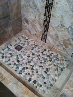 a tiled shower stall with pebbles in it