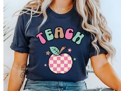 Elevate your Kindergarten or preschool Teacher apparel with this Retro teacher shirt. Design features a retro apple with TEACH across the top,  perfect for a new teacher gift, back to school shirt, first day of school teacher shirt or a gift for a librarian. Give as a gift for teacher appreciation week. **Check out my Etsy shop for more teacher gift ideas https://www.etsy.com/shop/DesertSunriseShop?ref=dashboard-header§ion_id=48532573 PRODUCT Bella and Canvas 3001 Unisex Adult Short Sleeve Tee H Trendy Fall T-shirt For School, Trendy Teacher Appreciation T-shirt For Back To School, Trendy School T-shirt For Fall, Teachers Appreciation Week Gifts, New Teacher Gifts, School Tees, Teacher Tees, Teacher Appreciation Week, New Teachers