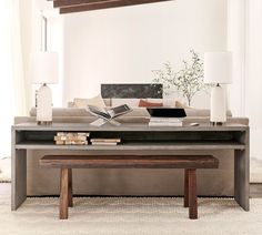 a living room with a couch, coffee table and two lamps on top of it