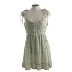 This Dress Is So Cute, Sage, Green With Yellow And White Daisies. Lining. Spaghetti Straps And Tie On Front Bodice With Opening. Ruffles Around Bottom Of Dress And Small Ruffle Around Waist Line. Never Worn. Polyester Lining And Polyester Shell. Summer Cami Mini Dress, Spring Sundress With Spaghetti Straps And Lining, Spring Mini Dress With Adjustable Spaghetti Straps, Spring Mini Dress With Spaghetti Straps And Adjustable Straps, Spaghetti Strap Sundress For Casual Occasions, Spring Mini Dress With Spaghetti Straps, Spring Cami Sundress With Adjustable Straps, Cami Sundress With Adjustable Straps For Spring, Spring Cotton Mini Dress With Spaghetti Straps