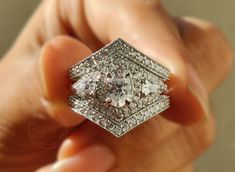 a diamond ring is being held in the palm of someone's hand with their fingers