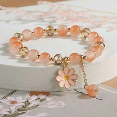 Introducing Our Stunning Peach Pink Color Flower Charm Glass Beaded Bracelet A Beautiful Accessory That Will Add A Touch Of Feminine Elegance To Any Outfit! This Bracelet Is Crafted With Care And Features Delicate Glass Beads In A Gorgeous Peach Pink Color That Exudes Softness And Sophistication. With Its Adjustable Length, This Bracelet Can Comfortably Fit Most Wrist Sizes. The Stretchy Band Ensures A Secure And Flexible Fit, Allowing You To Easily Slide It On And Off Without Any Hassle. The Fl Elegant Flower Crystal Bracelet For Spring, Elegant Flower Shaped Crystal Bracelet For Spring, Spring Rose Gold Flower Bracelets, Spring Rose Gold Flower Bracelet, Elegant Flower Beaded Bracelets For Spring, Elegant Spring Flower Beaded Bracelets, Elegant Beaded Flower Bracelets For Spring, Elegant Adjustable Crystal Bracelet For Spring, Pink Flower-shaped Beaded Crystal Bracelet