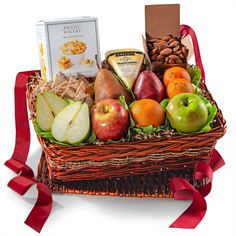 a basket filled with fruit and nuts next to a box of crackers on a white background