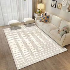 a living room with a white couch and rug on the floor next to a window