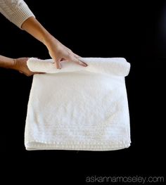 a person holding a white towel on top of a black surface