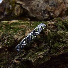 a silver ring sitting on top of a rock