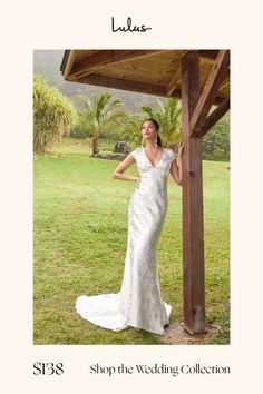 a woman in a wedding dress standing under a gazebo with palm trees behind her