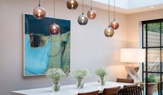 a dining room table with chairs and vases on it