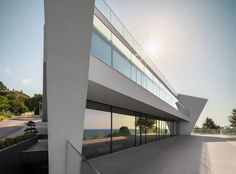 the sun shines brightly on an empty building with glass walls and balconies