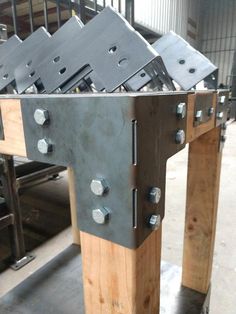 some metal and wood work benches in a warehouse or factory with steel studs on them