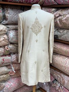 This beige white royal sherwani is brought into limelight with fine jaal embroidered coat enhanced with resham, pearl ,stone & cut dana work. The coat is styled with matching churidar pants. Size:40,42,44 Occasion: Wedding Ceremony or Reception WASH CARE INSTRUCTIONS - Please Dry clean only when it is applicable. Slight color variation is possible due to digital photography. Ready to Ship! Elegant Raw Silk Sherwani With Intricate Embroidery, Elegant Sherwani In Raw Silk With Straight Kurta, Elegant Raw Silk Sherwani Straight Kurta, Elegant Raw Silk Bandhgala With Naqshi, Elegant Bandhgala With Naqshi In Raw Silk, Fitted Cream Salwar Kameez With Intricate Embroidery, Cream Sherwani With Chikankari Embroidery And Long Sleeves, Bollywood Style Raw Silk Churidar With Naqshi, Cream Nehru Jacket With Resham Embroidery Long Sleeve