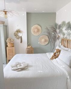 a white bed sitting in a bedroom next to two baskets