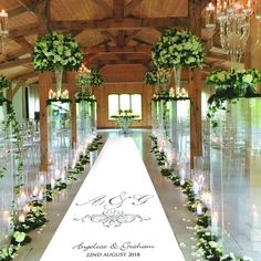 a long table with flowers and candles on it in the middle of an indoor venue