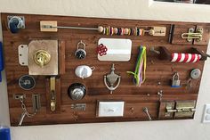 a wall mounted wooden board with various items attached to it and hanging on the wall