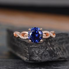 a tan gold ring with a blue sapphire and diamond accents on top of a rock