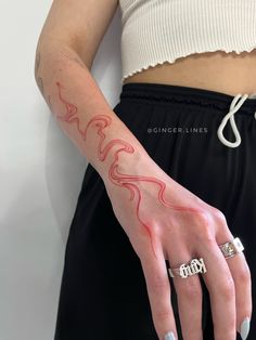 a woman's hand with red ink on her left arm and the word love written across it