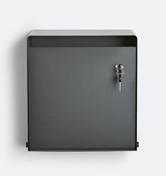 a black metal cabinet with two keys on the front and one key in the back