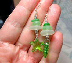 "Three pairs of carefully matched pieces of genuine sea glass are complemented by a Peridot Swarovski Starfish Bead. All findings are sterling silver. Earrings measure 2.25\" from the top of the earwires. These are dangly and have lots of movement and sparkle." Handmade Green Starfish Jewelry, Handmade Green Starfish-shaped Jewelry, Green Starfish Charm Jewelry As Gift, White Puppies, Feather Design, Lampwork Glass Beads, Beach Glass, Focal Bead, Lampwork Beads