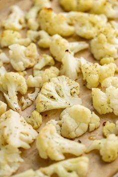 cauliflower florets sitting on top of a cutting board with seasoning