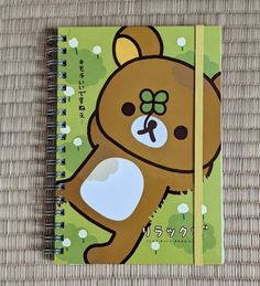 a spiral notebook with a brown bear on it