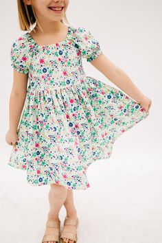 Woven twirls dress in lovely emerald and fuchsia floral. Cute Green A-line Dress, Playful Pink Dress With Smocked Back, Cute Smocked Back Dress For Garden Party, Cute Flowy Dress With Ditsy Floral Print, Cute Garden Party Dress With Smocked Back, Playful Floral Print Dress For Garden Party, Casual Floral Print Twirl Dress For Spring, Fitted Floral Print Twirl Dress For Summer, Pink Short Sleeve Twirl Dress With Floral Print