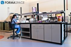 a woman sitting at a desk in a lab