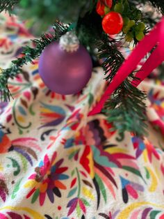 a christmas tree with ornaments on it and a pink ribbon hanging from the top of it