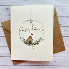 a happy holidays card with a house and wreath