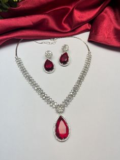 Gorgeous fine quality imitation jewellery red faux diamonds studded necklace with white gold rhodium plating and matching Earrings Item contains: Necklace and earrings Highest quality and craftsmanship Necklace Fitting is adjustable Earrings Closure: Pushback Necklace Closure: chain with Hook Details-  -Handmade item -Delivery from a small business in India -Materials: white rhodium, stones, cz, zircon, American diamond -Jewellery type: Earrings, Necklace -Style: Art deco *CARE INSTRUCTION* You can use Jewelry for years together with the help of below jewelry care instructions. * Protect from sharp blows/scratches and extreme temperature. * Avoid contact with perfumes, sprays, chemicals and water. * Keep in a clean, dry and airtight Zip-pouch. * Wipe it using a soft cloth after each use. Red Diamond Necklace, Affordable Necklaces, Necklace Closure, Pendant Earrings Set, Indian American, American Diamond Jewellery, Diamond Jewelry Necklace, Studded Necklace, Diamond Gift