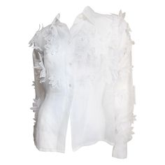 A stunning white semi sheer silk shirt, blouse from Dolce & Gabbana. It has a shirt collar and long sleeves with button cuffs. The sleeves, upper front and back are covered in appliques of layered varying sized flowers in the same fabric each individually finished- very work intensive. The effect is stunning. it buttons up the front with mother of pearl buttons. Fits sizes Medium, Large. Bust 46" Sleeves 25" Length 24"