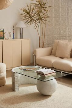 a living room filled with furniture and a glass coffee table on top of a rug