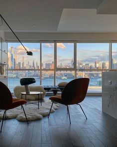 a living room filled with furniture next to a large window covered in lots of windows