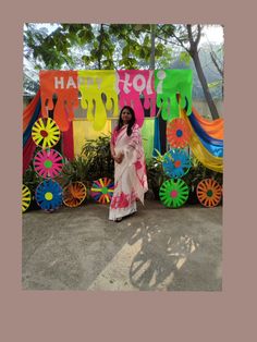 a woman standing in front of a colorful sign