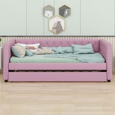 a pink daybed with pillows on it in a room