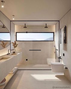 a modern bathroom with two sinks and large mirrors on the wall, along with a walk in shower