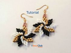 a pair of earrings with black, white and gold beads hanging from it's hooks