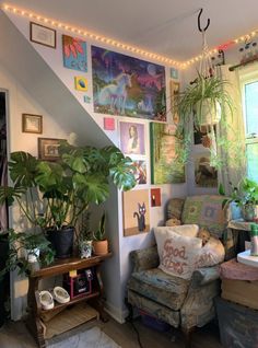 a living room filled with lots of plants and pictures on the wall