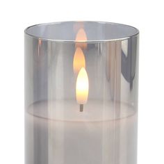 a lit candle in a clear glass container