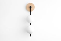 two white balls mounted to the side of a wall with a wooden circle on it