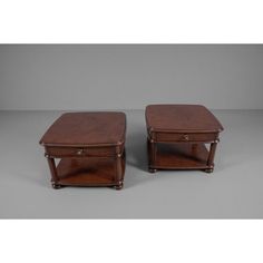 a pair of wooden end tables sitting on top of a gray floor next to each other