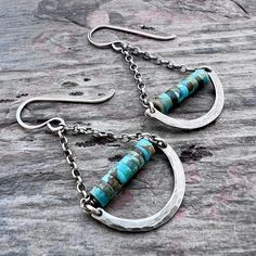 These chandelier earrings are handmade from genuine turquoise and sterling silver. The small natural stones are framed by hammered curves which I have formed and textured by hand. The turquoise beads and hammered curves dangle from sterling silver chains and earwires. Silver has been oxidized and polished to create an antique patina finish. Be sure to see all photos and video for size and color reference. Turquoise Beads: About 2x4mmTotal Earring Length (including earwire): About 1 and 7/8"Total Earring Weight: About 1.9 grams per one earring Handmade Turquoise Chandelier Earrings In Sterling Silver, Turquoise Hammered Dangle Earrings, Turquoise Hammered Dangle Jewelry, Nickel-free Sterling Silver Turquoise Chandelier Earrings, Silver Chandelier Earrings, Silver Chandelier, Color Reference, Silver Chains, Patina Finish