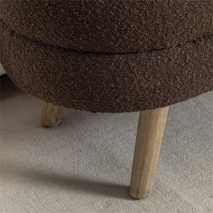 a brown ottoman sitting on top of a carpet covered floor