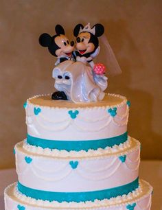 a wedding cake with mickey and minnie on top